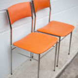 Pair of chrome metal chair and orange skai