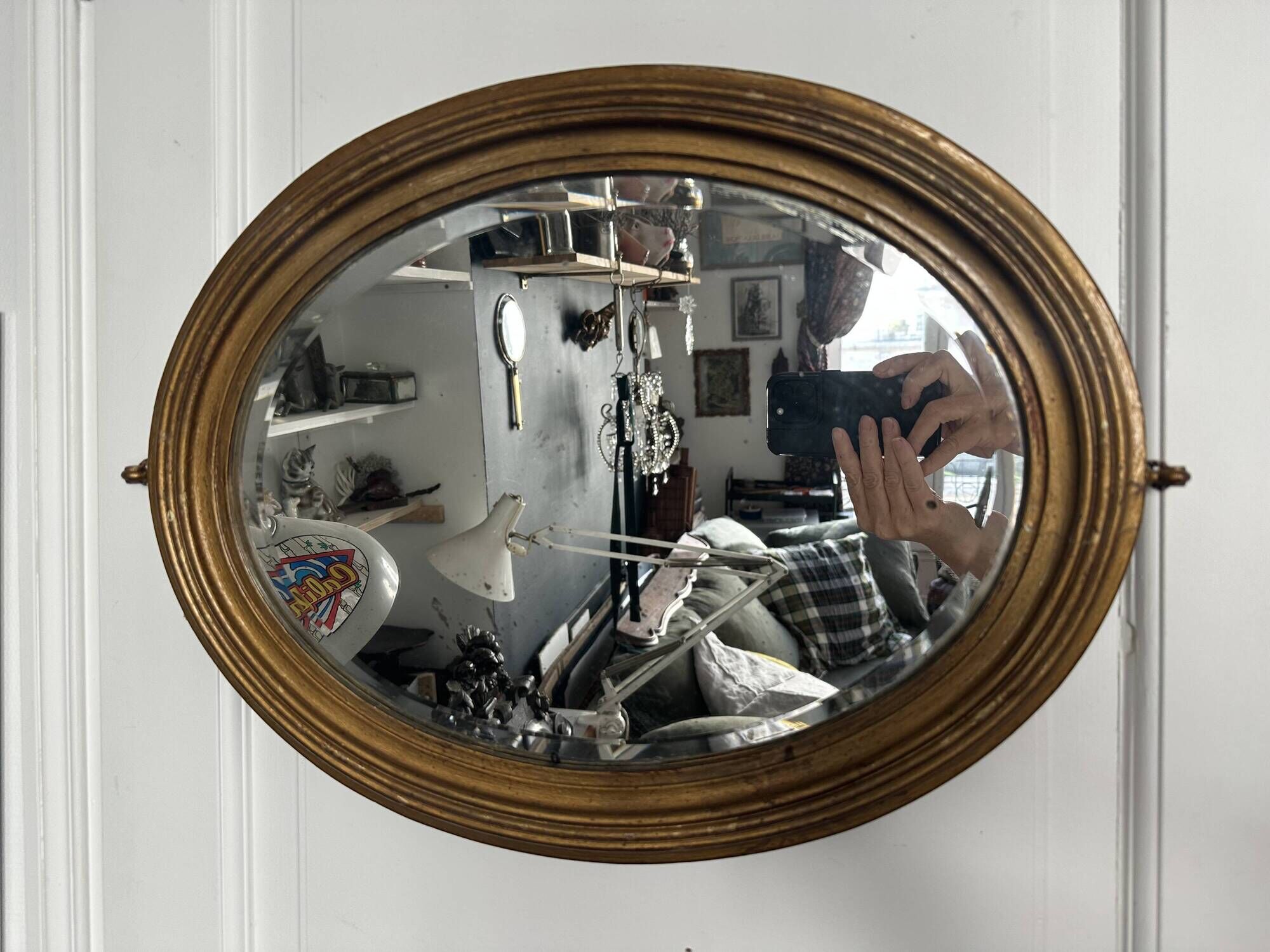 Antique oval mirror in gilded wood, bevelled mercury glass, 19th century.