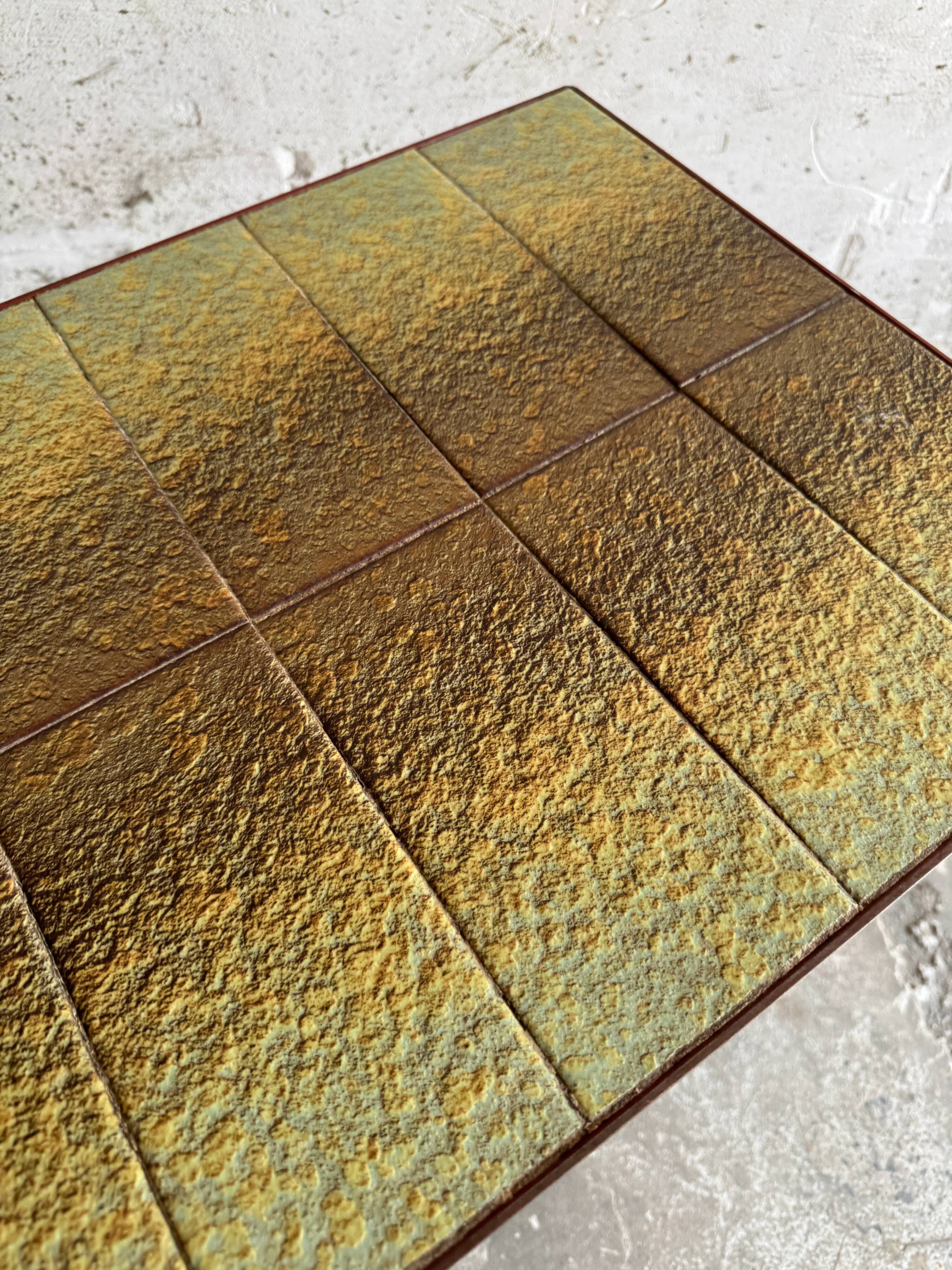 Vintage terracotta-red metal side table with glazed brown-green ceramic tile surfaces