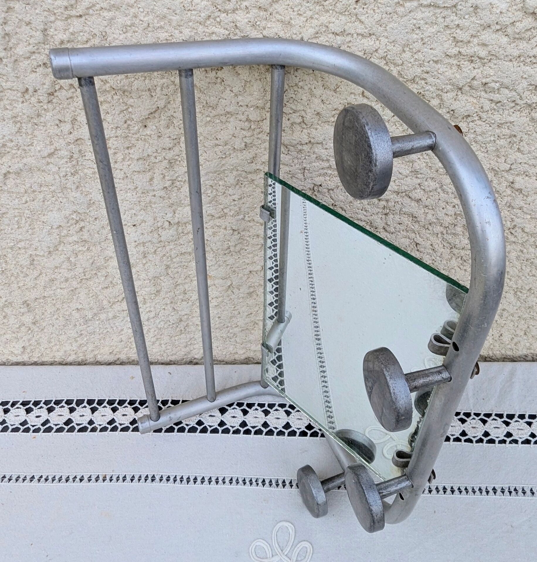 Vintage train style wall-mounted hat rack with angled mirror.
