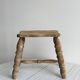 Antique wooden stool with four turned legs.