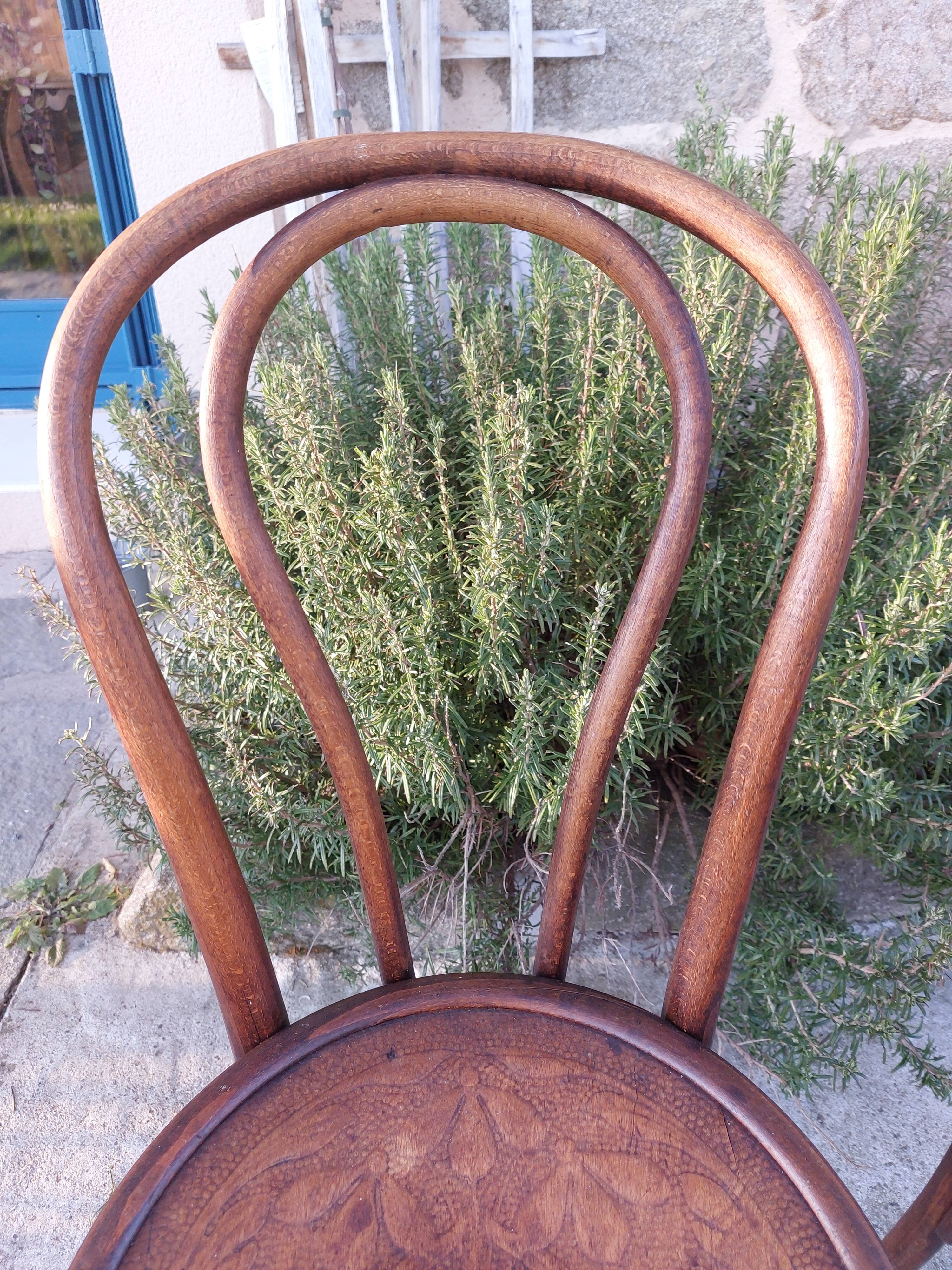 pair of round wooden chairs with a pattern on the seat