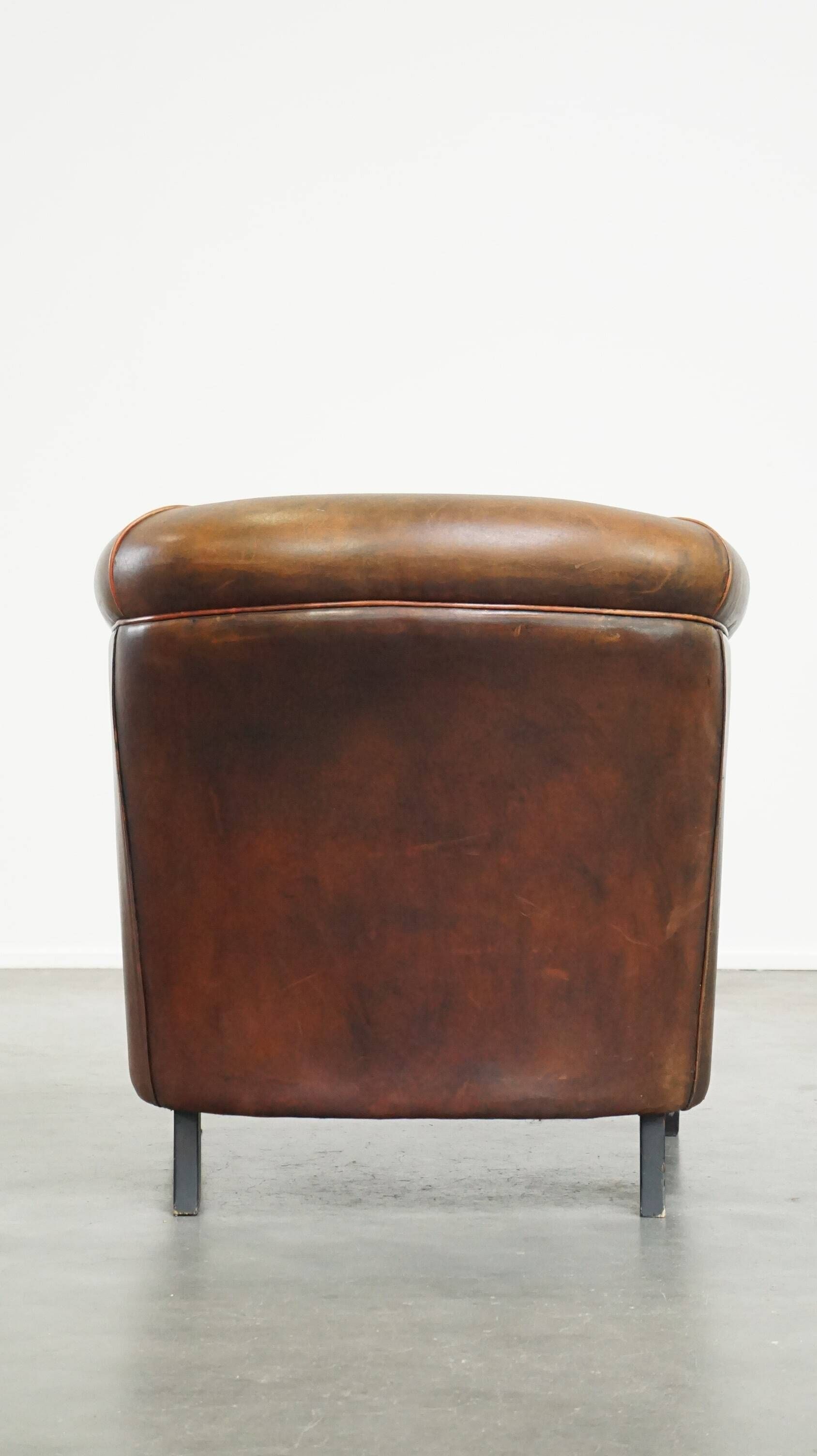 Neat, elegantly finished, cozy sheepskin club armchair with a fixed seat cushion
