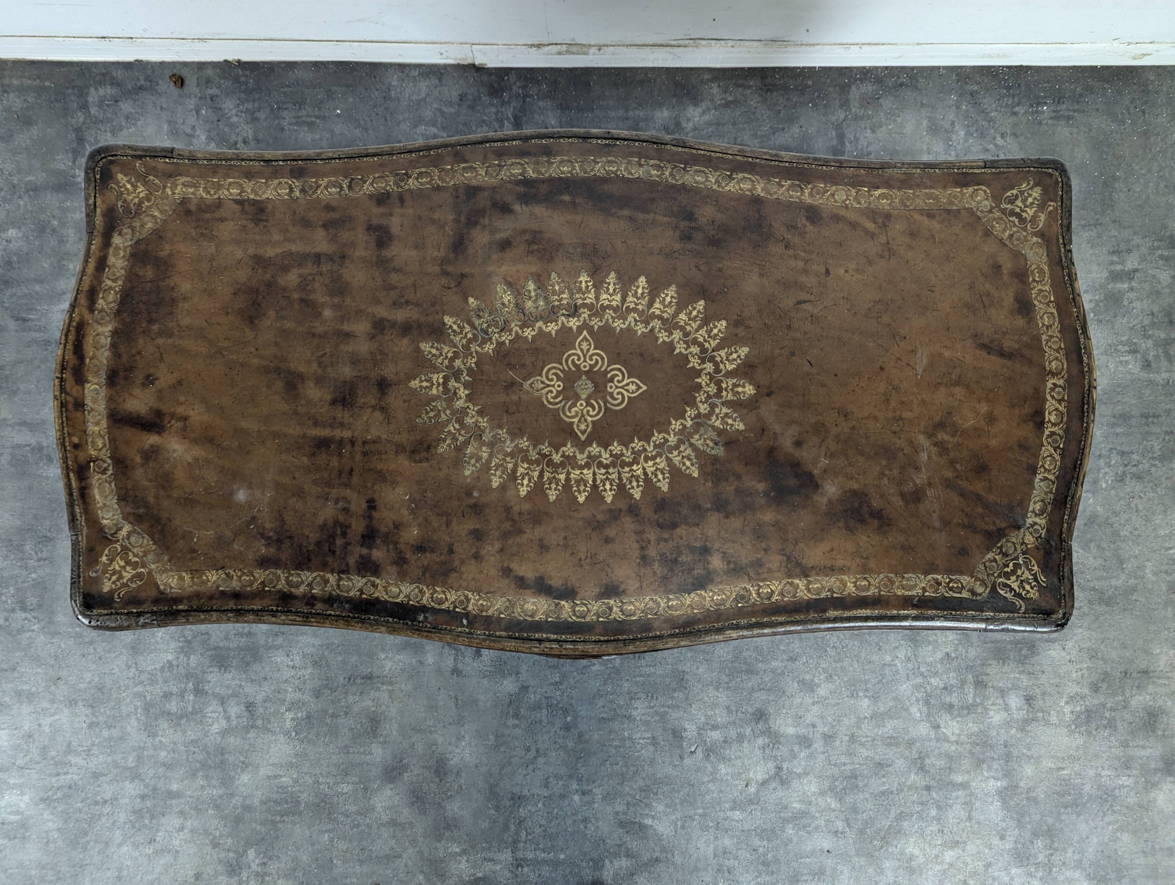 Louis XV coffee table in carved walnut with a gilded leather top.