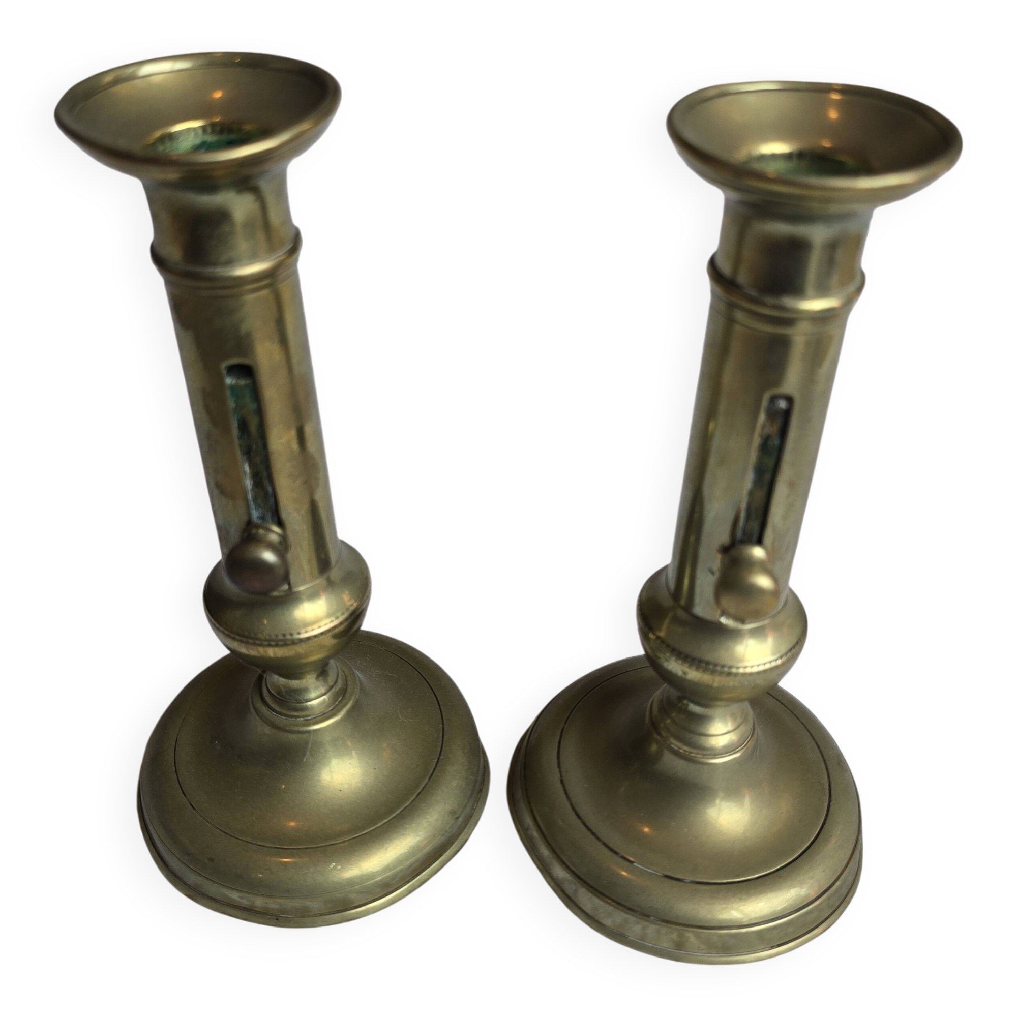 Pair of antique brass candlesticks with adjustable push mechanism from the 19th century.
