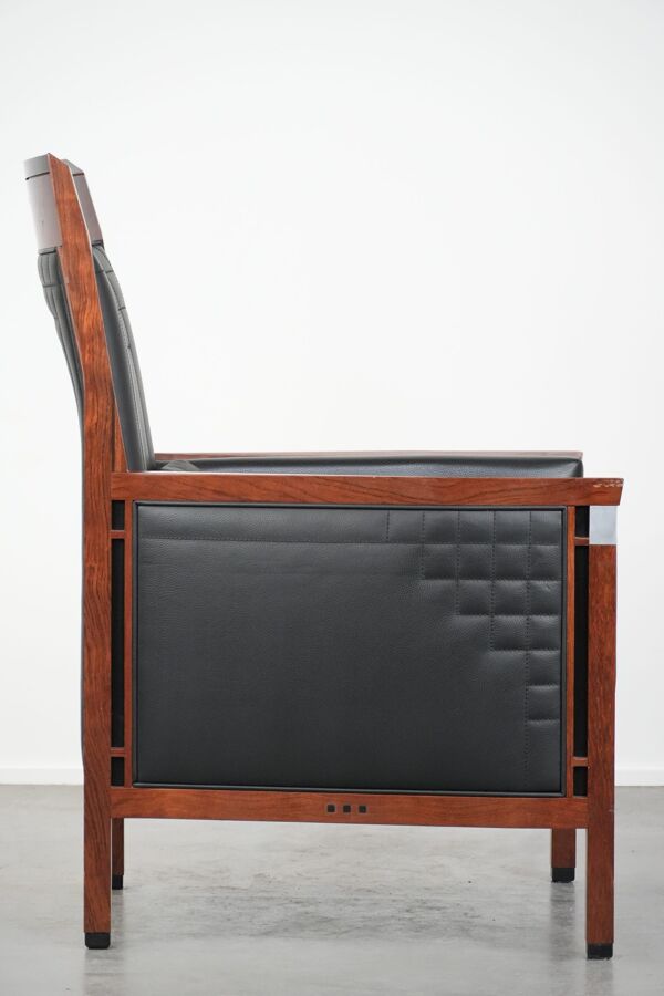 Fauteuil design Art Déco en cuir noir avec couture décorative.