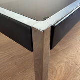 Large designer coffee table from the 70s in chrome, smoked glass, and faux leather.