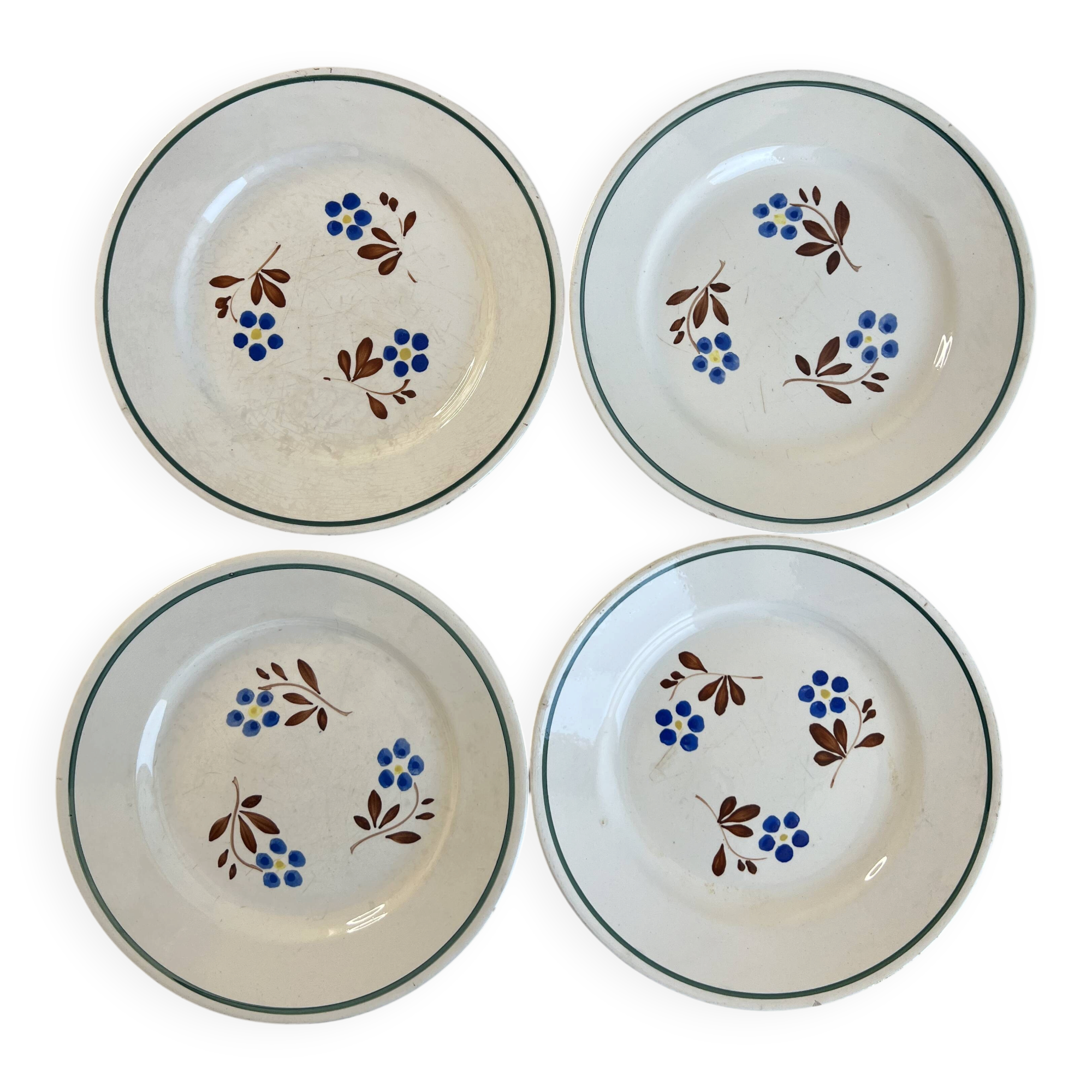Set of 4 small flat plates with floral designs.