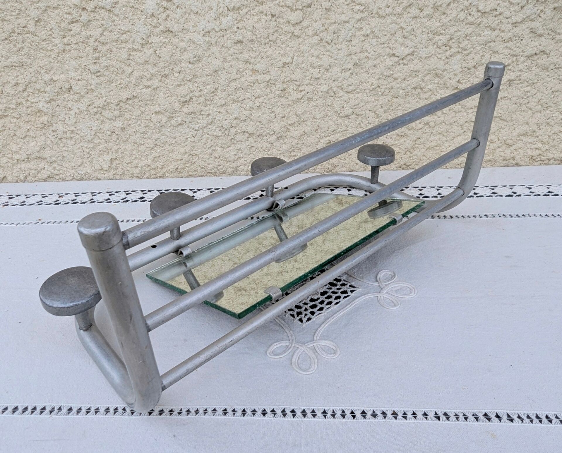 Vintage train style wall-mounted hat rack with angled mirror.