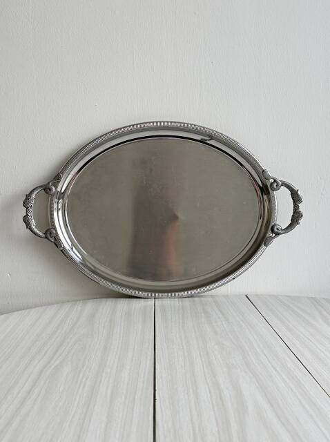 Large stainless steel serving platter with fish-shaped handles.