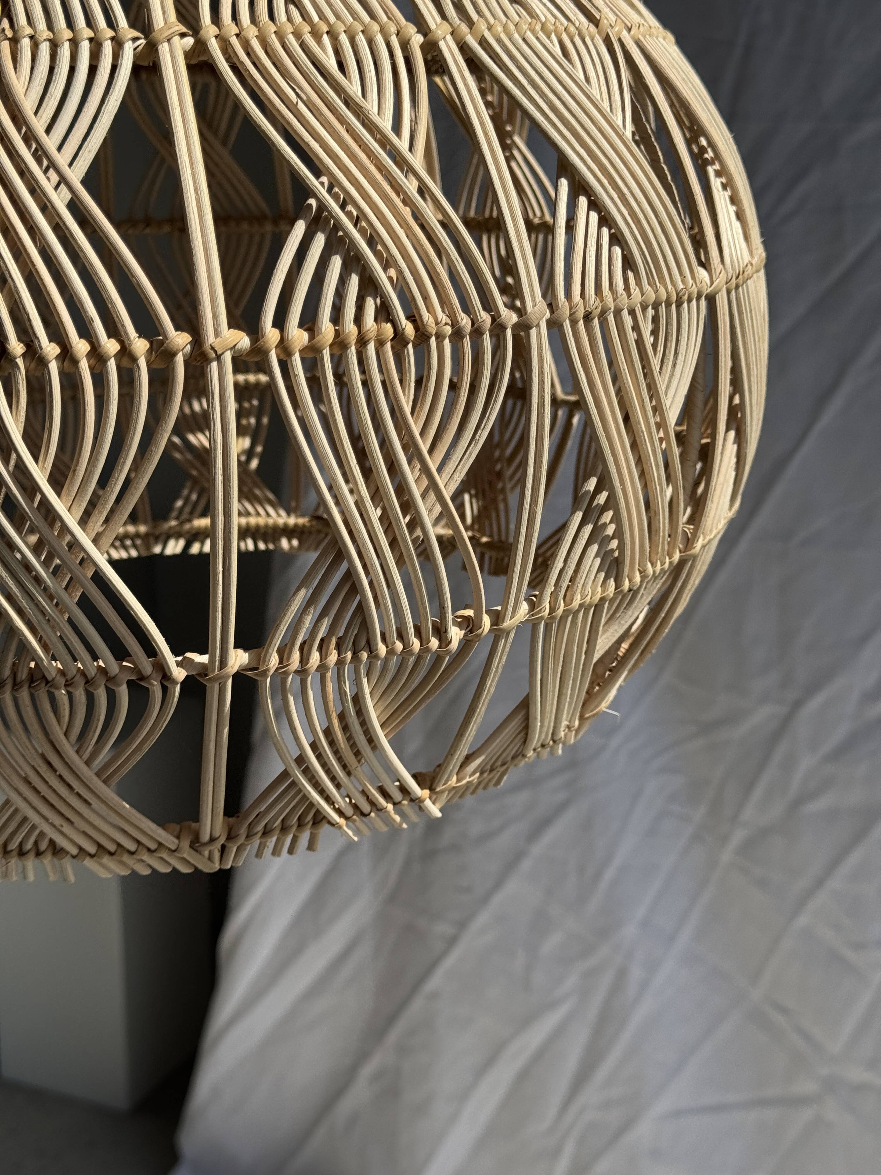 Suspension or rattan lampshade in the shape of a woven bulb.