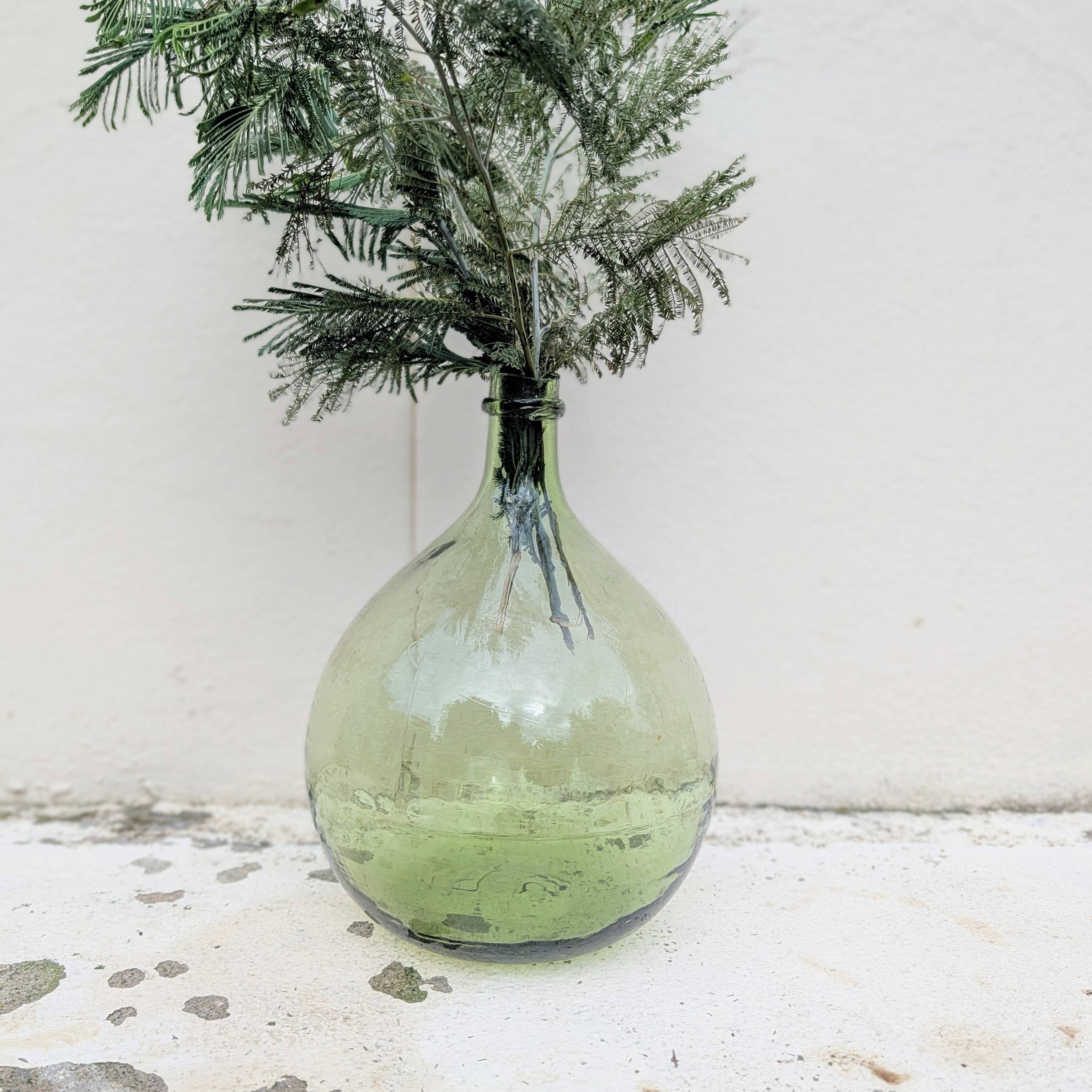 Give me a green glass jug made of blown glass.
