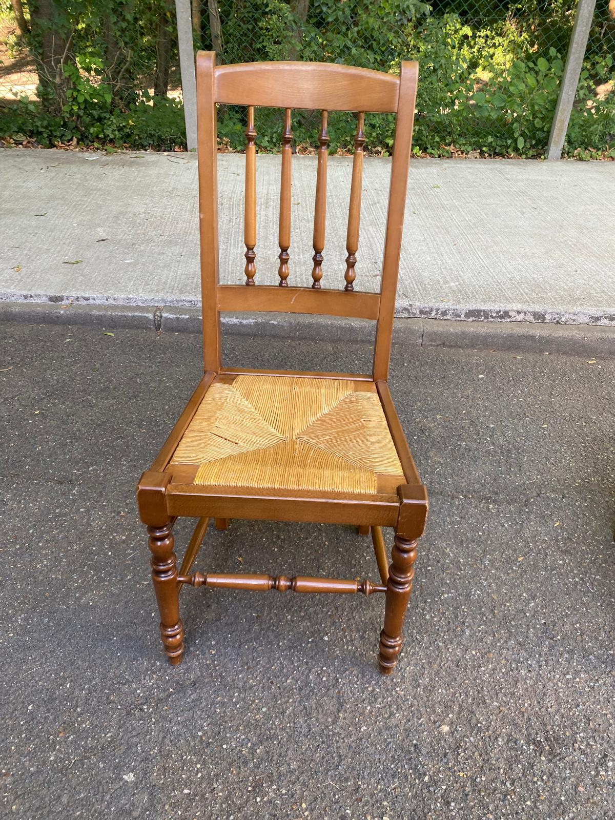 Solid wood chair with a straw seat and carved bar backrest.