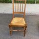 Solid wood chair with a straw seat and carved bar backrest.