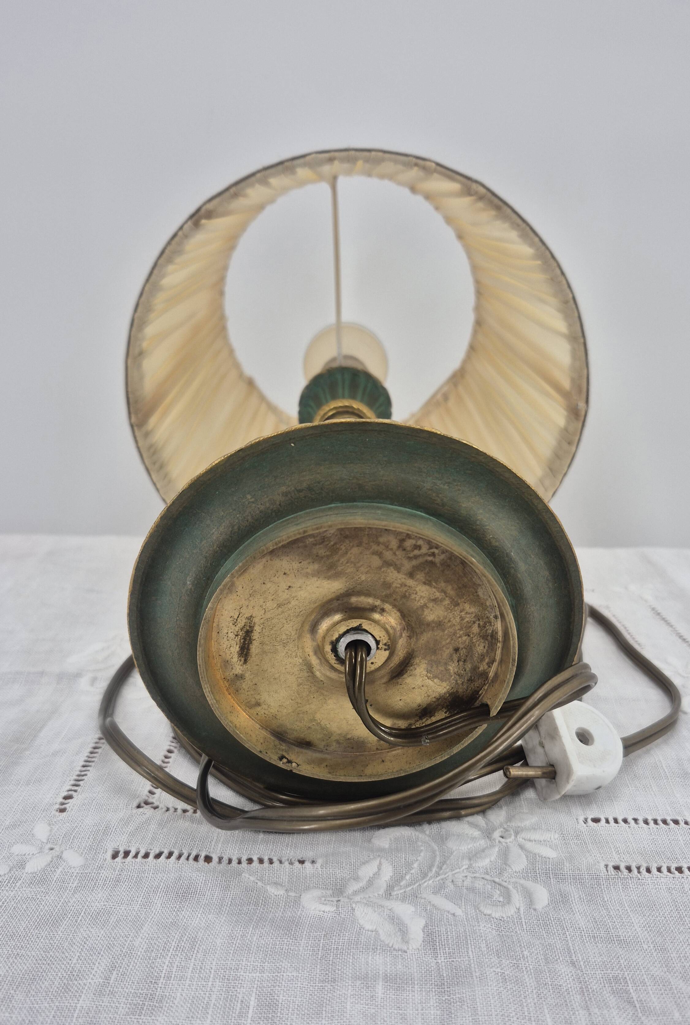 Brass table lamp with green patina and empire-style fabric shade.