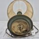 Brass table lamp with green patina and empire-style fabric shade.