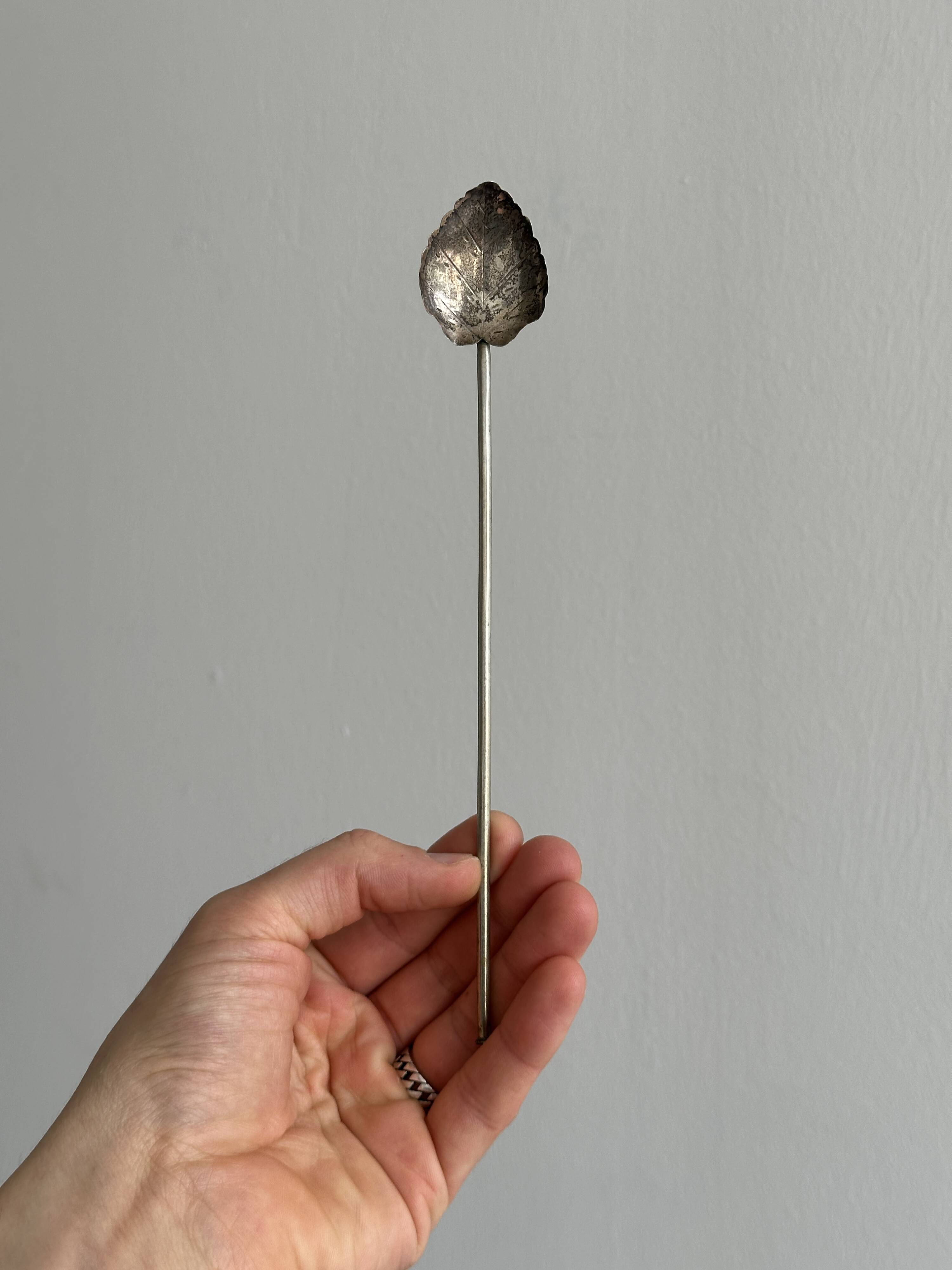 Vintage spoon in old metal, leaf pattern