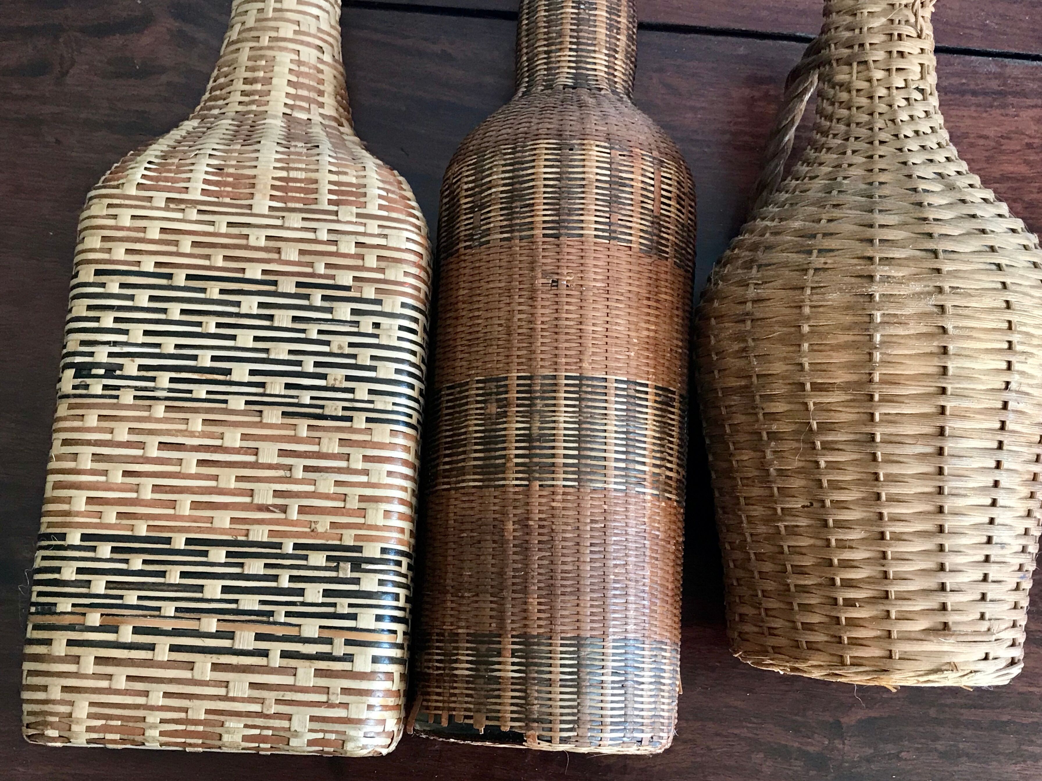 Set of three vintage rattan bottles