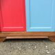Vintage oak compass foot cabinet with 2 sliding doors painted red and blue
