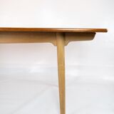 Dining table in teak and oak with extensions designed by Hans J. Wegner