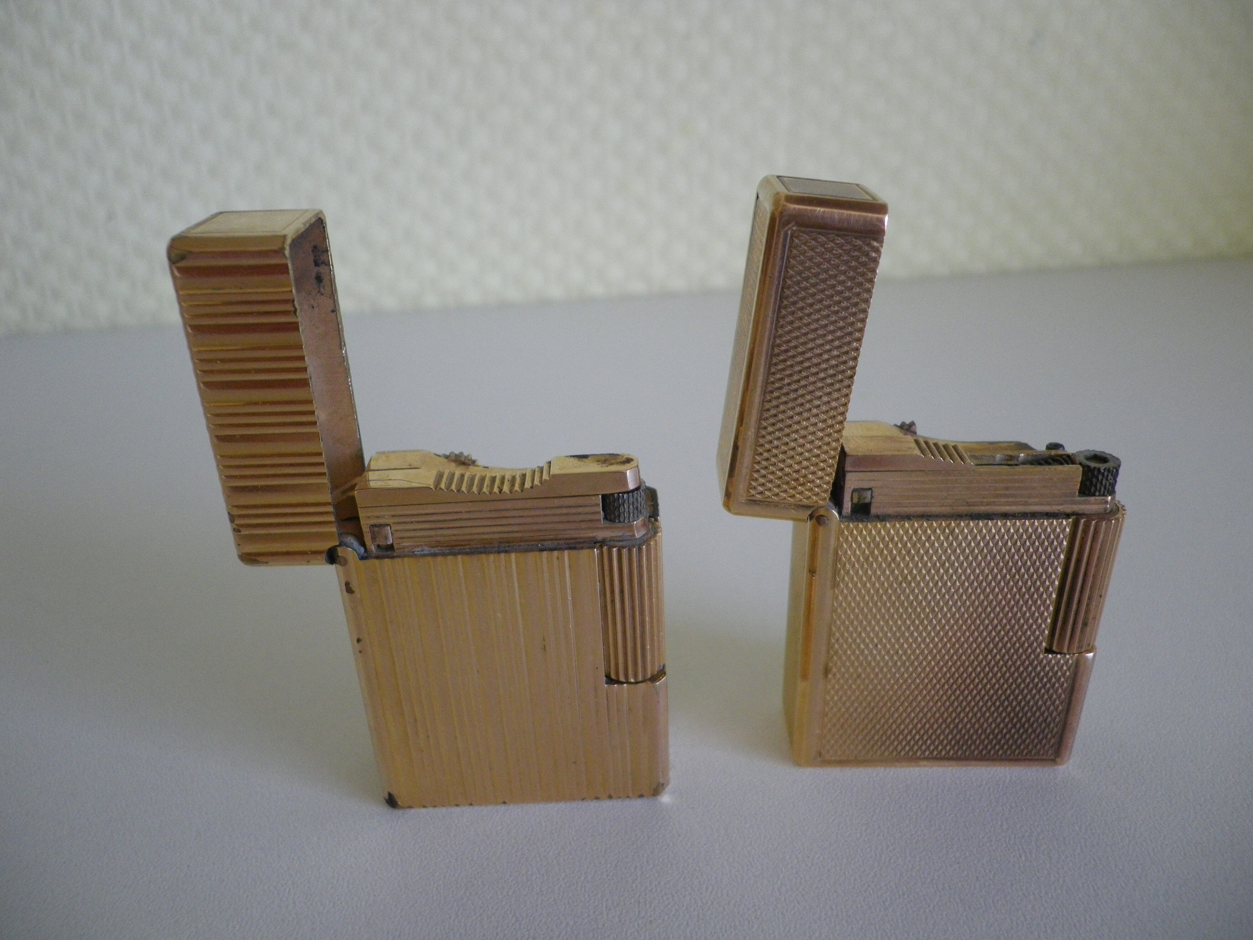 2 st dupont lighters, gold plated, punches, numbered, 1 striated pattern, 1 hammered pattern, 70s