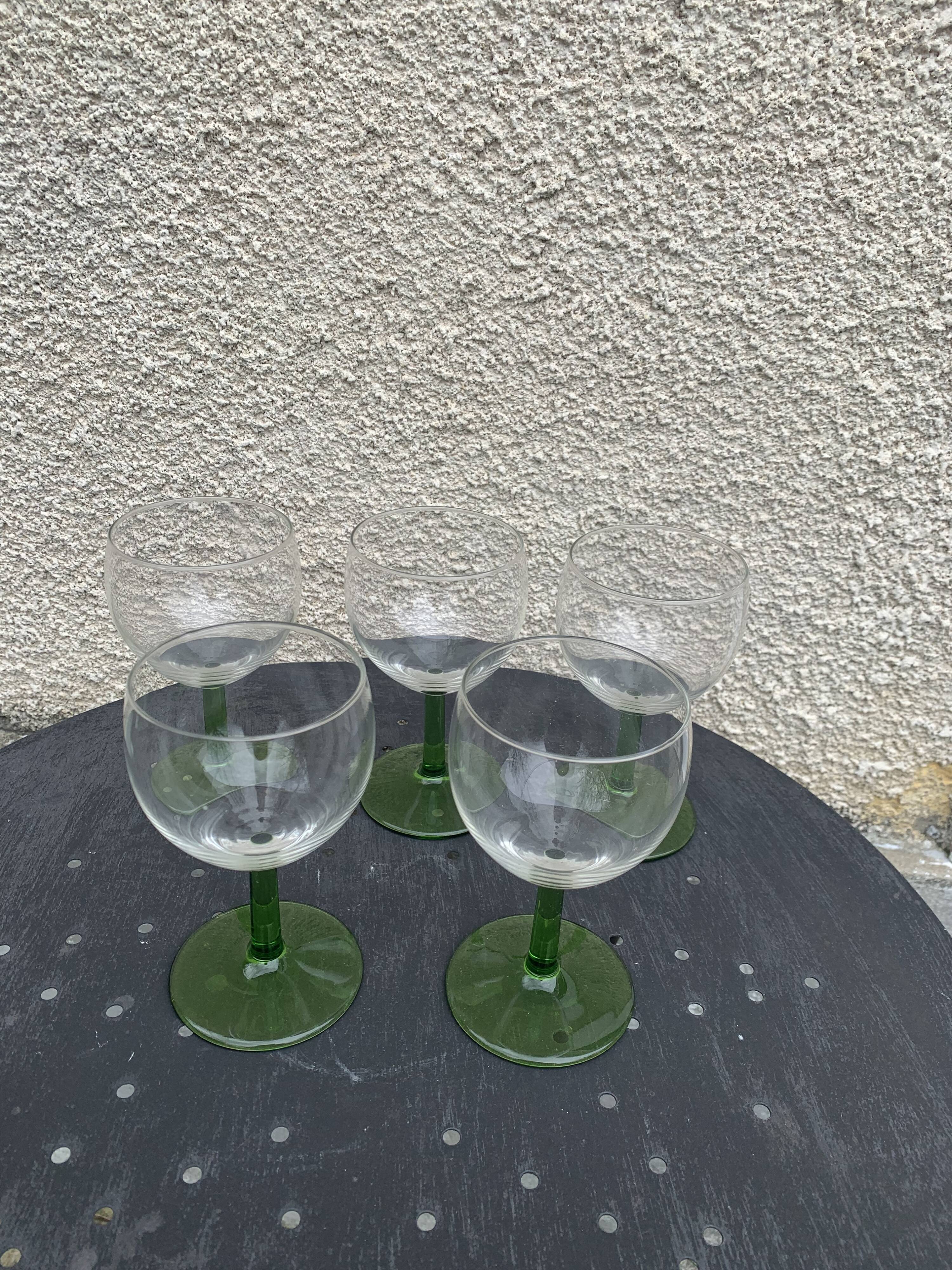 5 transparent glass glasses and green glass vase go