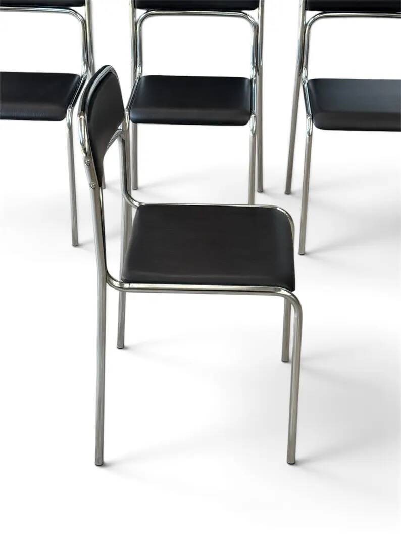 Bauhaus-style tubular steel chairs with black faux leather upholstery, Italian modernist dining room