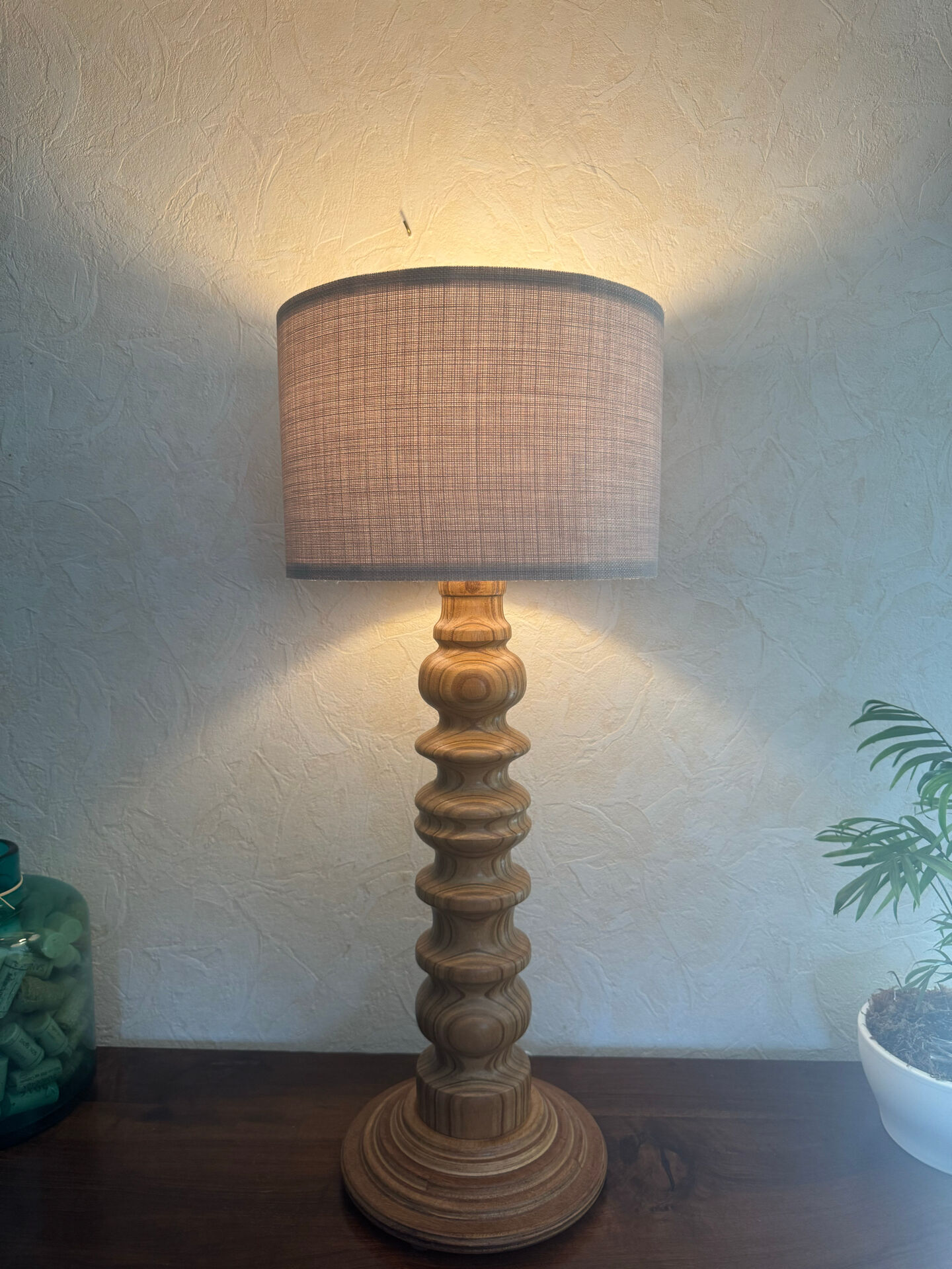 Wooden turned totem lamp with a linen shade in a vintage Scandinavian style.