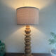 Wooden turned totem lamp with a linen shade in a vintage Scandinavian style.