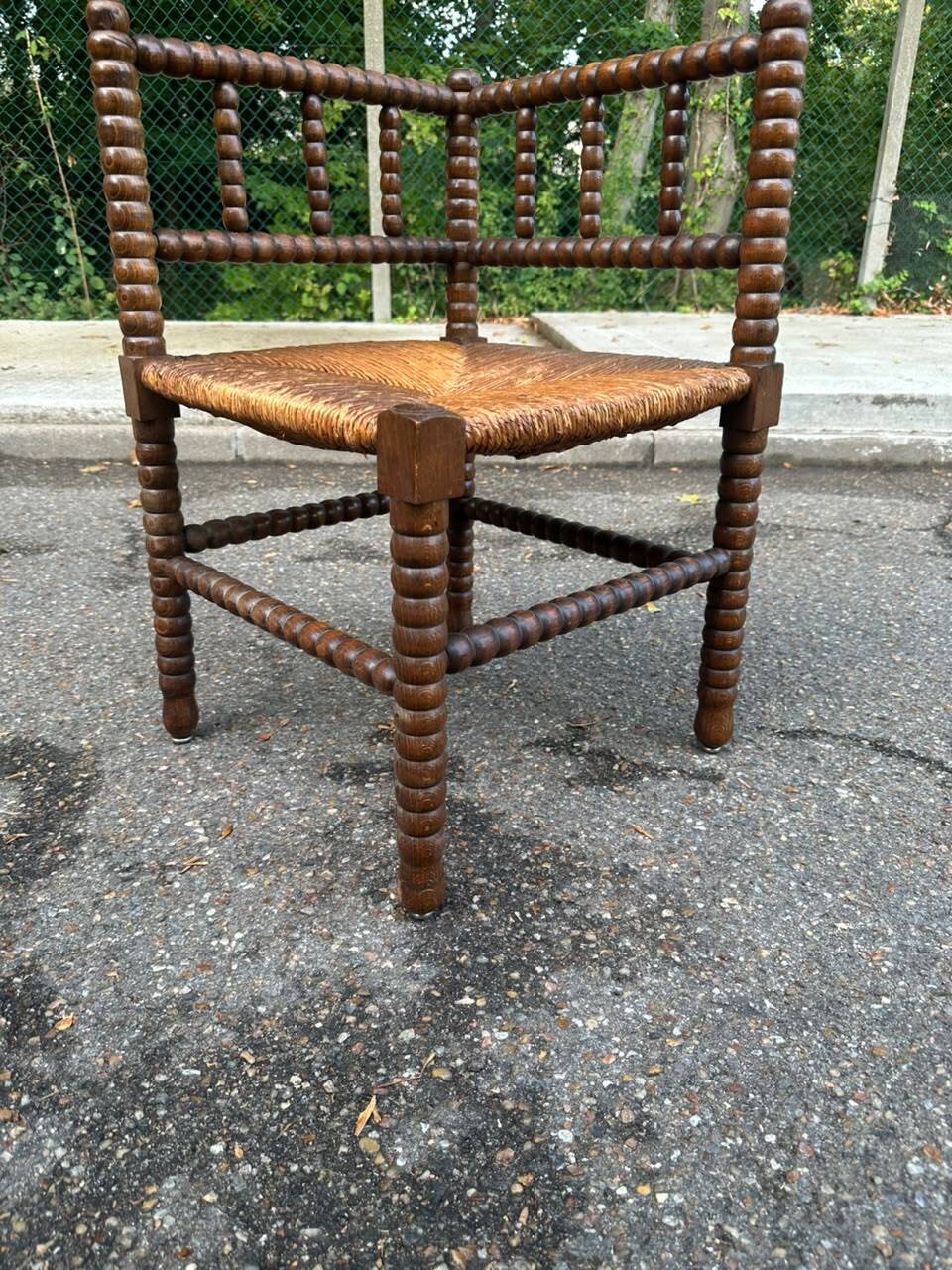 Brutalist corner chair in turned wood with straw bobbins, 1960.