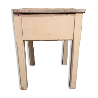 Small bedside table with wooden legs and metal-rimmed Formica lid tray
