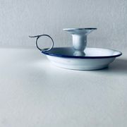 Old candle holder in white enameled metal