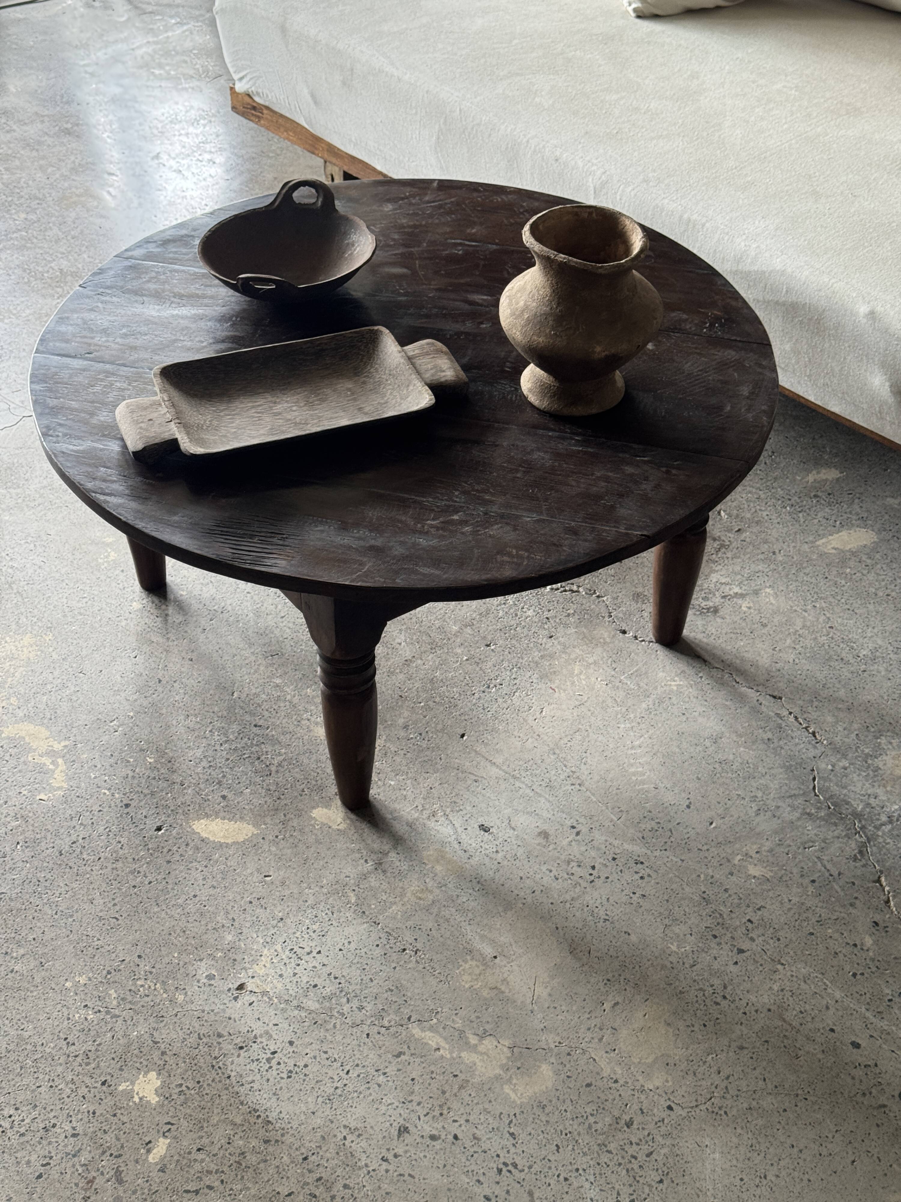 Coffee table, round antique Indonesian teak table with straight legs.