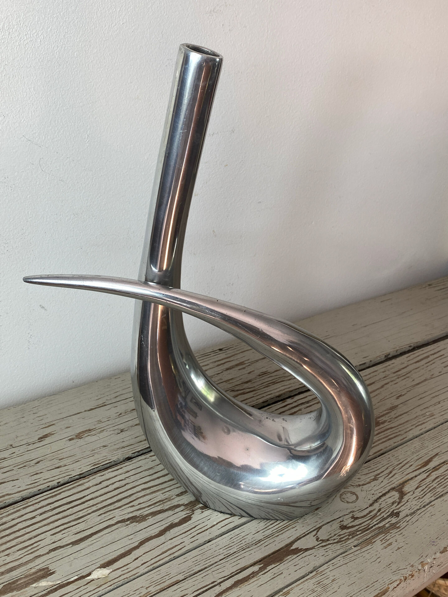 Sculptural vase design in polished aluminium.