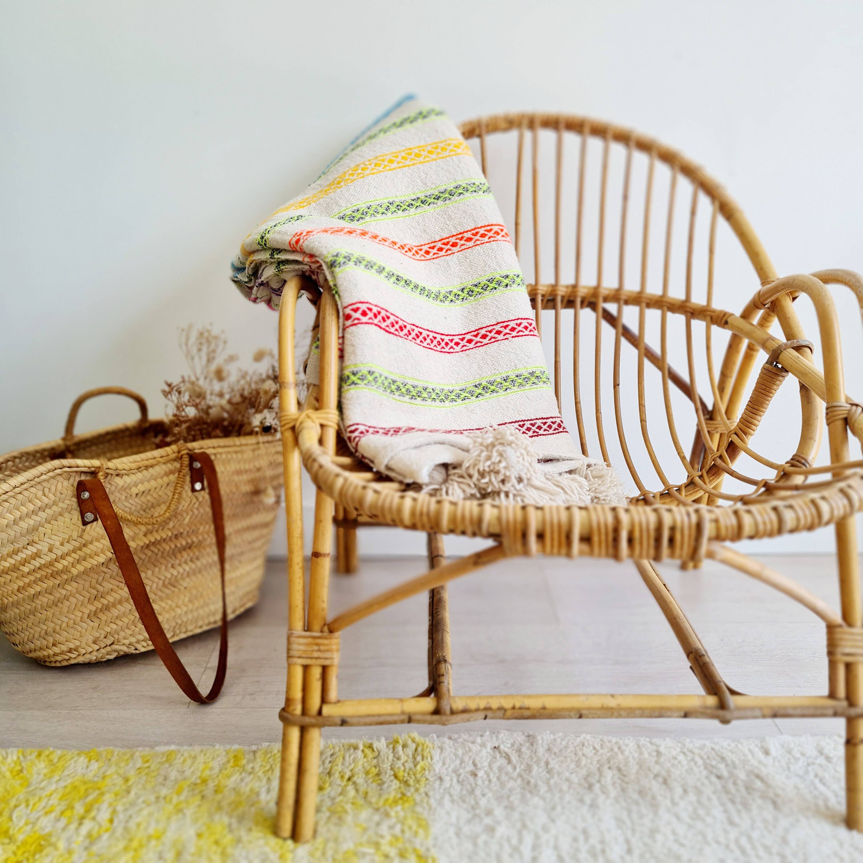 Plaid marocain en laine tissée main et décoré de rayures et pompons