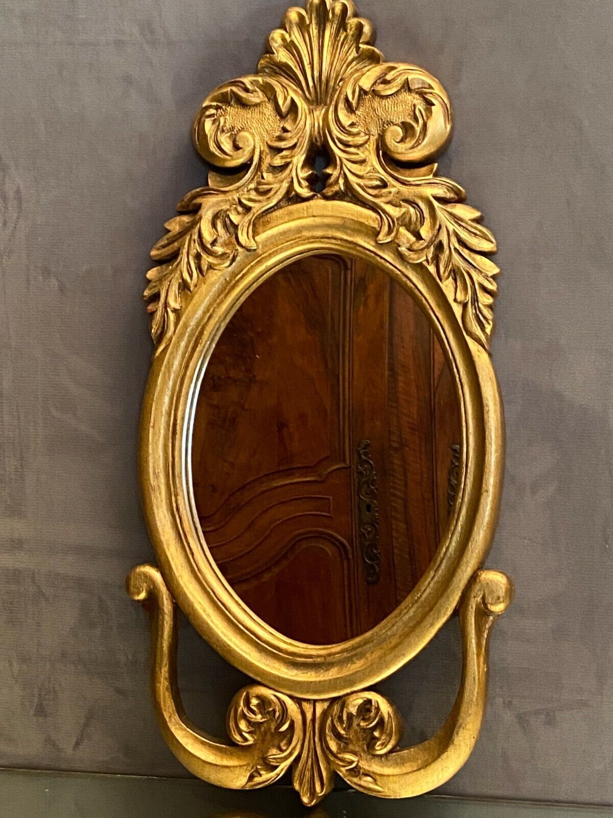 Oval view mirror in gilded wood with leafy decoration in Regency style