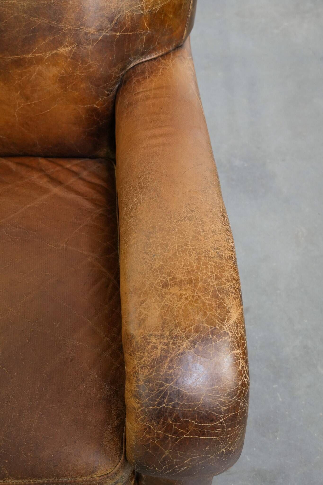 Charming and comfortable vintage armchair in grained cowhide leather with character