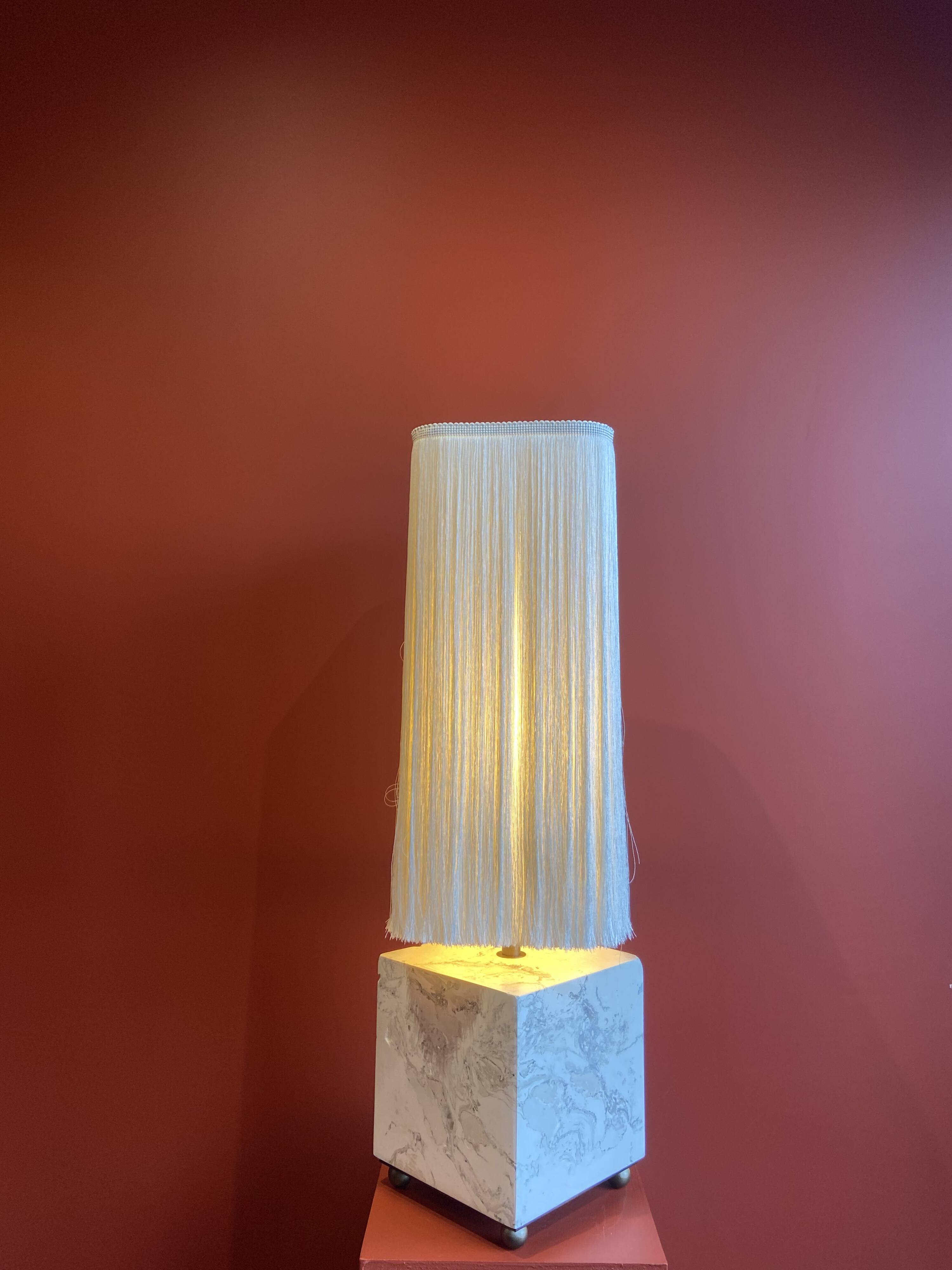 Beige marble stucco base, Houles white ecru fringed lampshade.