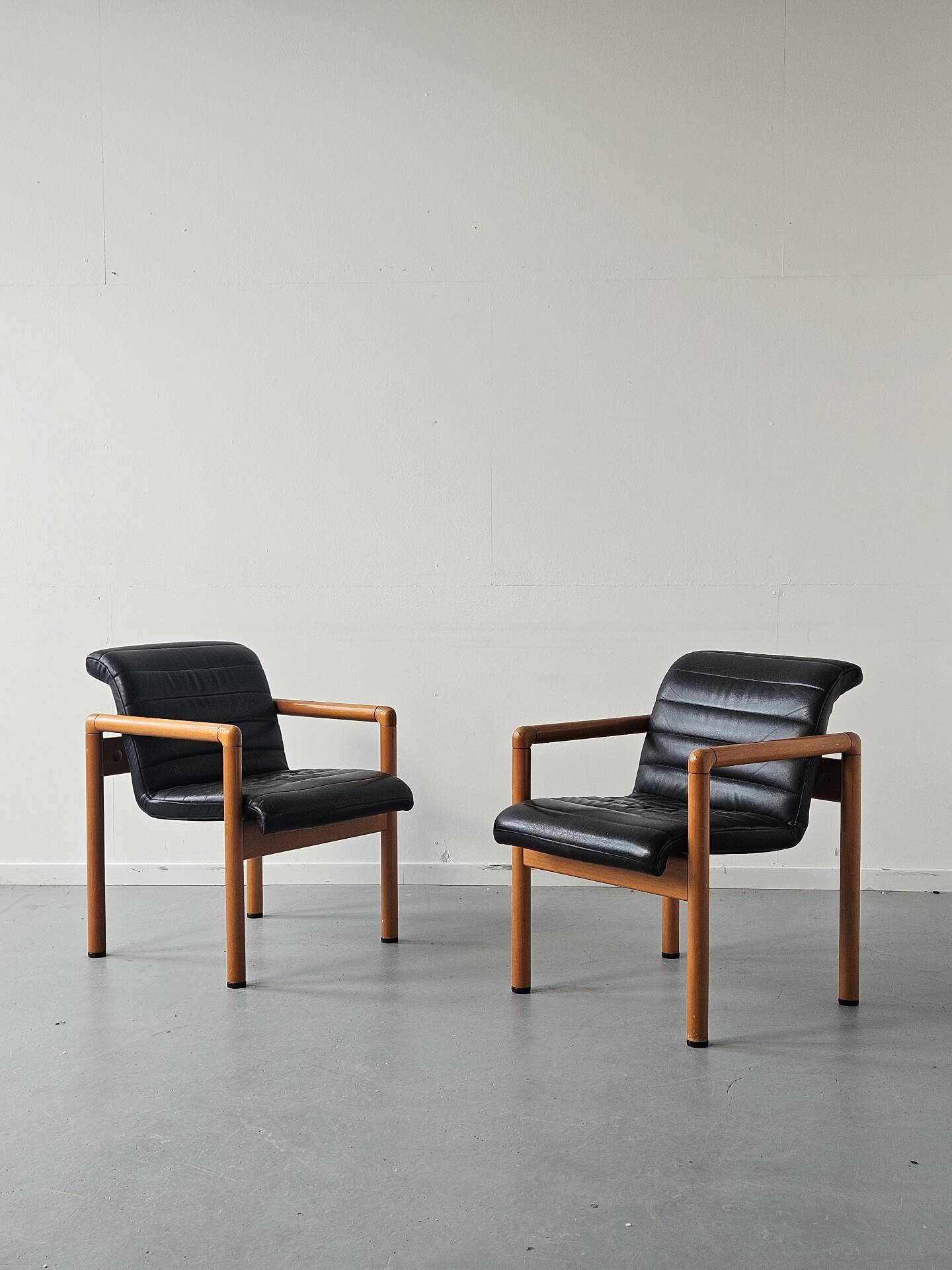 Pair of vintage Flototto armchairs in leather and wood, 1980s.