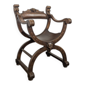 Curule chair Dagobert in carved walnut with lion heads.