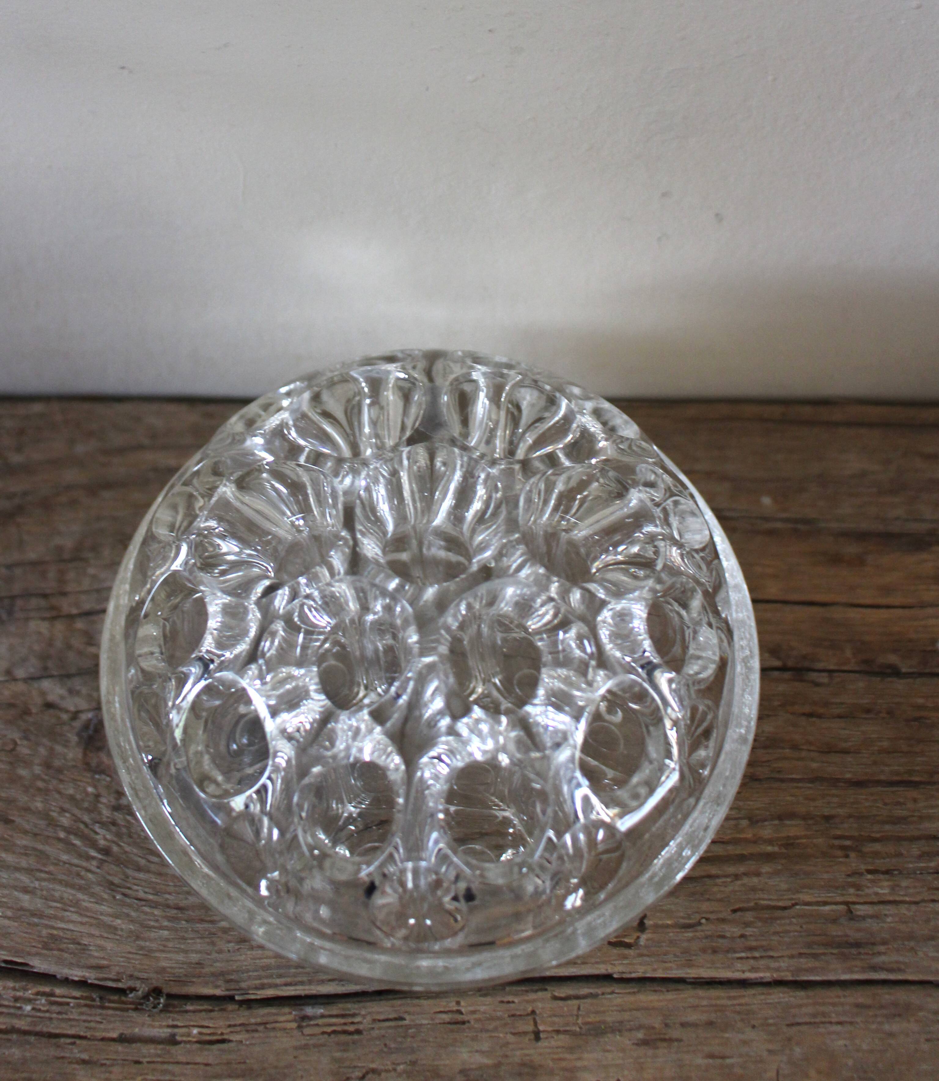 Large round glass flower frog vase with 19 holes.