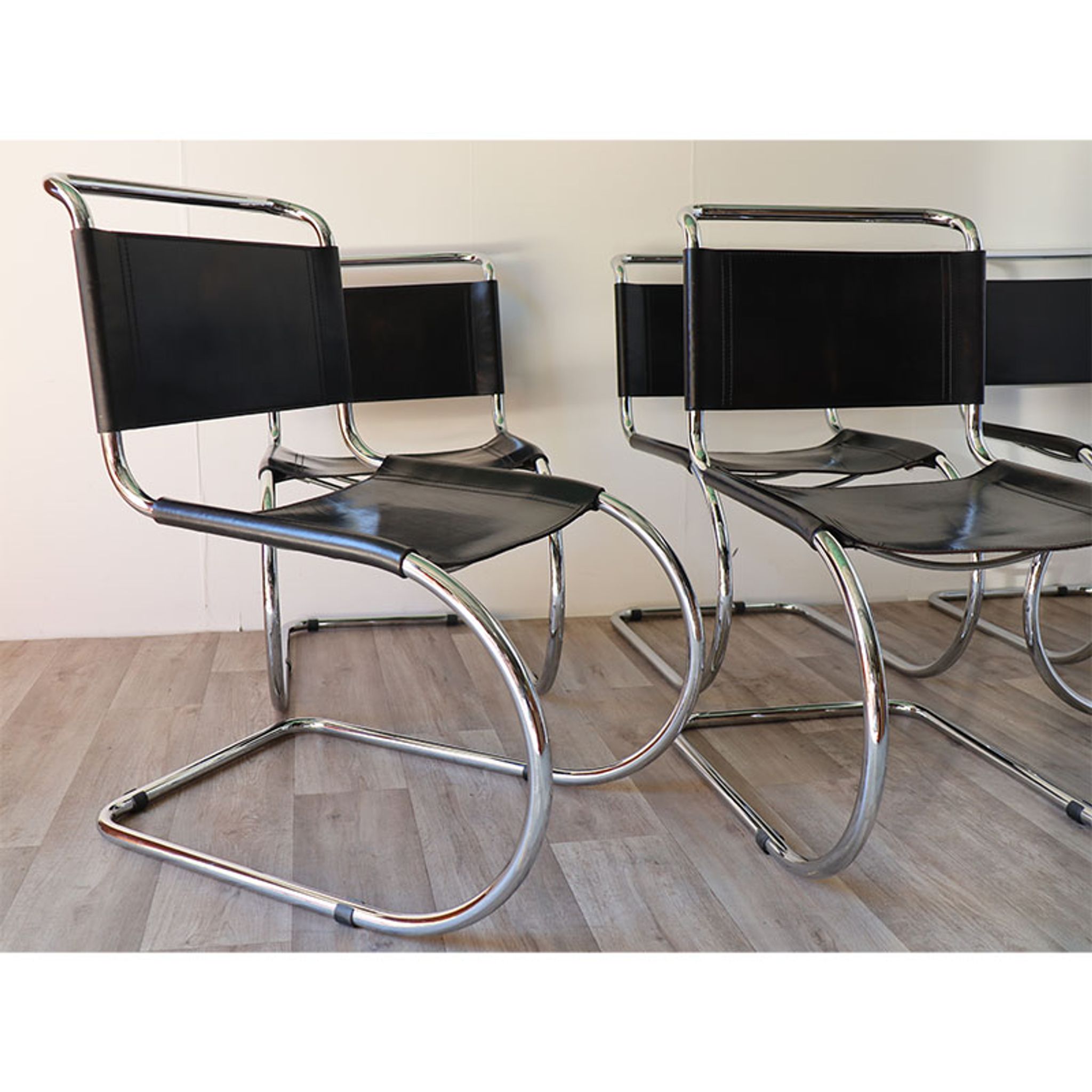 Series of 6 minimalist chairs in chrome metal and black leather around 1970
