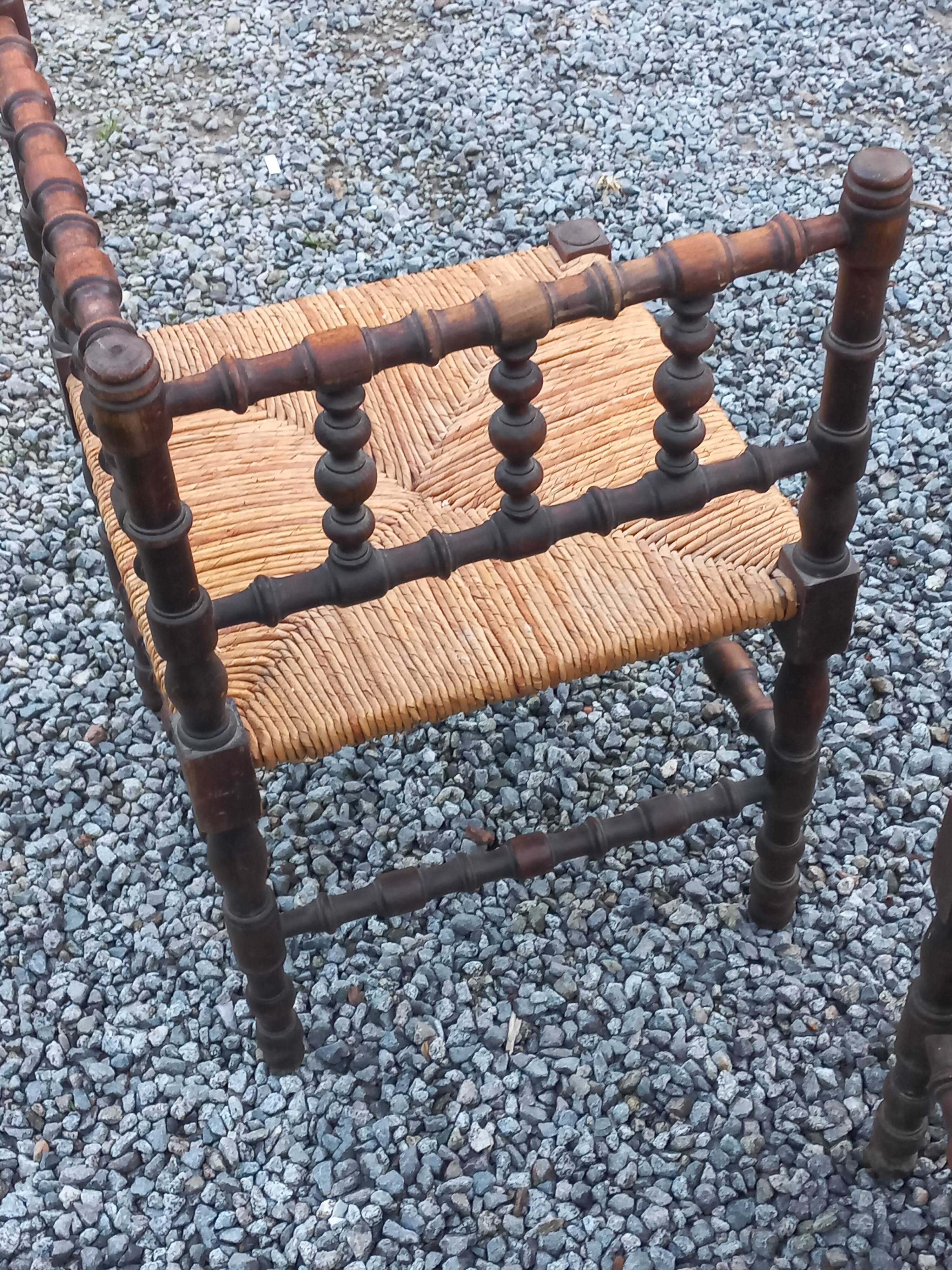Pair of angled armchairs with turned wood and rush seats from the 1960s.