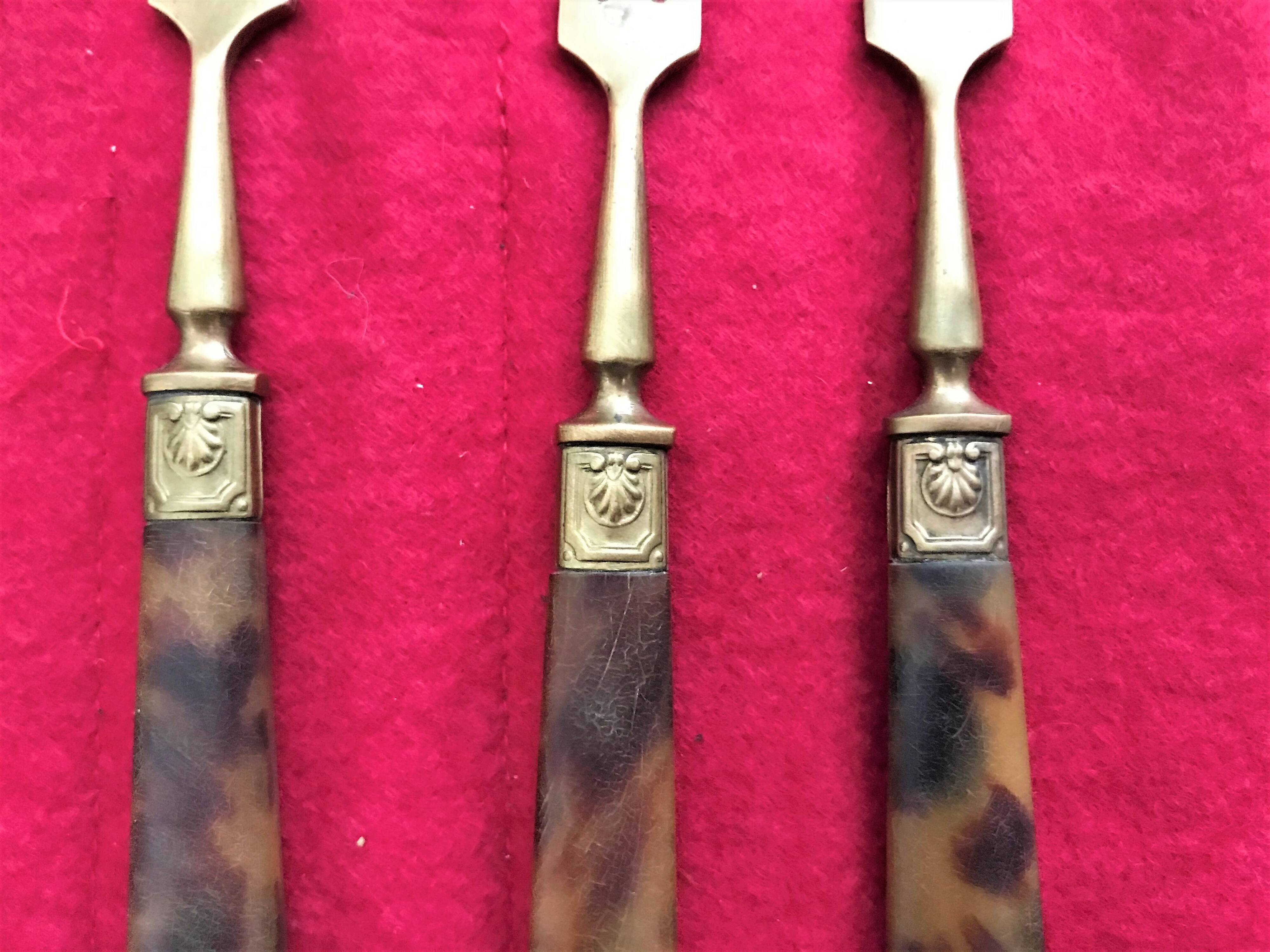 Table art, 12 fruit cutlery sets in gilded metal with horn from the early 20th century.