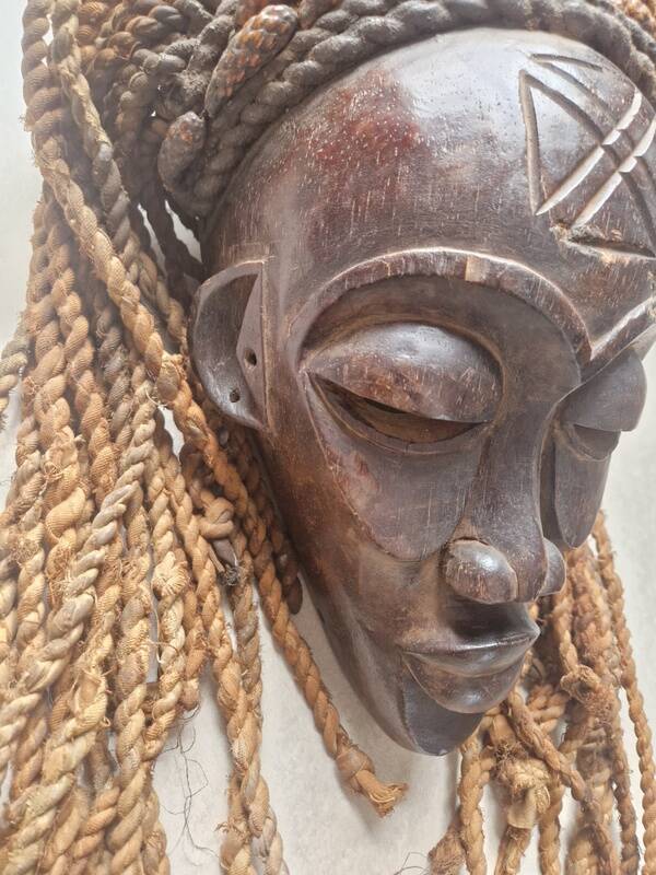 Chokwe Mwana Pwo mask in carved wood with a dark patina and rope hair