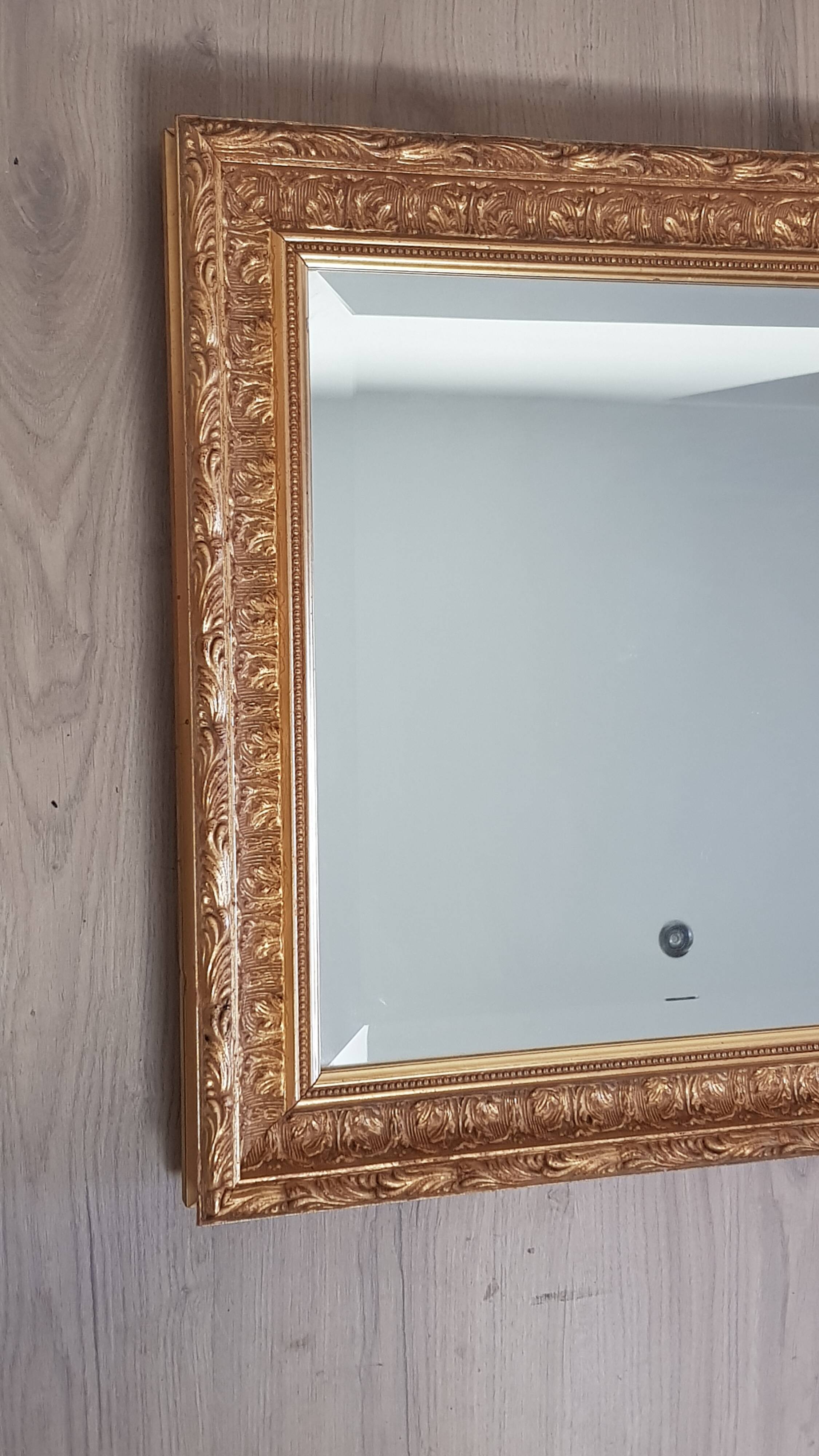 Mirror in gilded stucco wood and beveled glass