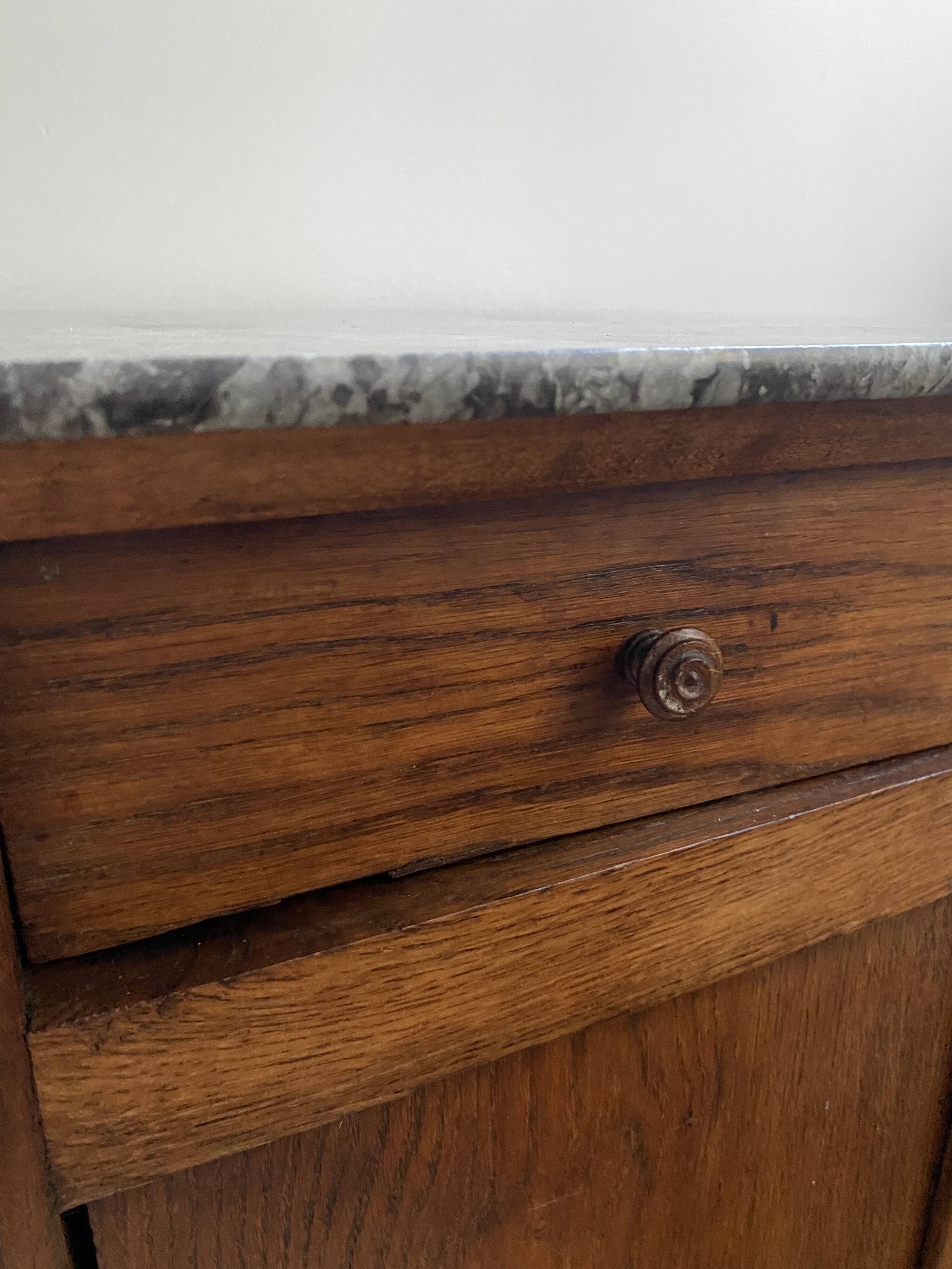 Vintage bedside table in the shape of a wooden column and a gray marble top