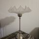 Table lamp with a silver base and a frilled shade.
