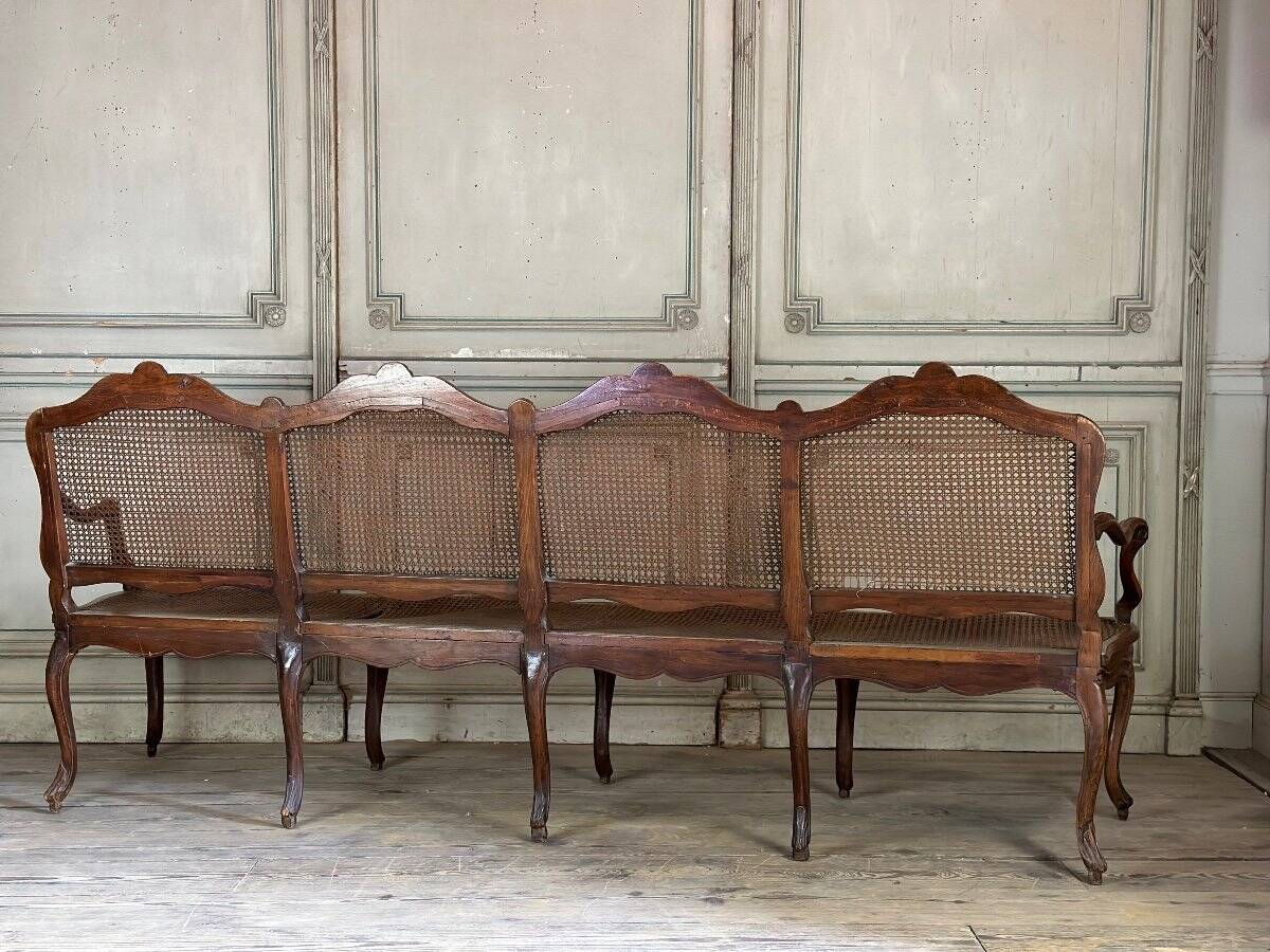 Grande banquette Louis XV en bois naturel mouluré et sculpté, France XVIIIème siècle