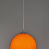 Pair of spherical pendant lights in orange opaline, France circa 1970.